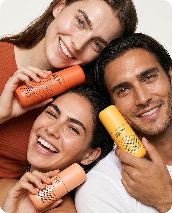 Diverse group of people holding Cleanser Base, Serum Base, and Moisturizer Base bottles.