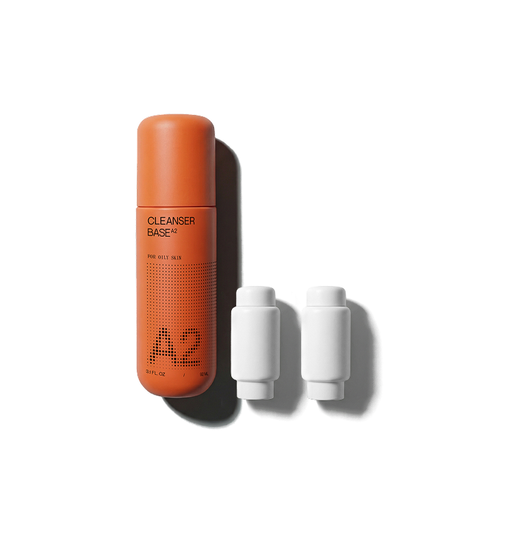 Cleanser Base bottle with two white concentrate pods on a black background.