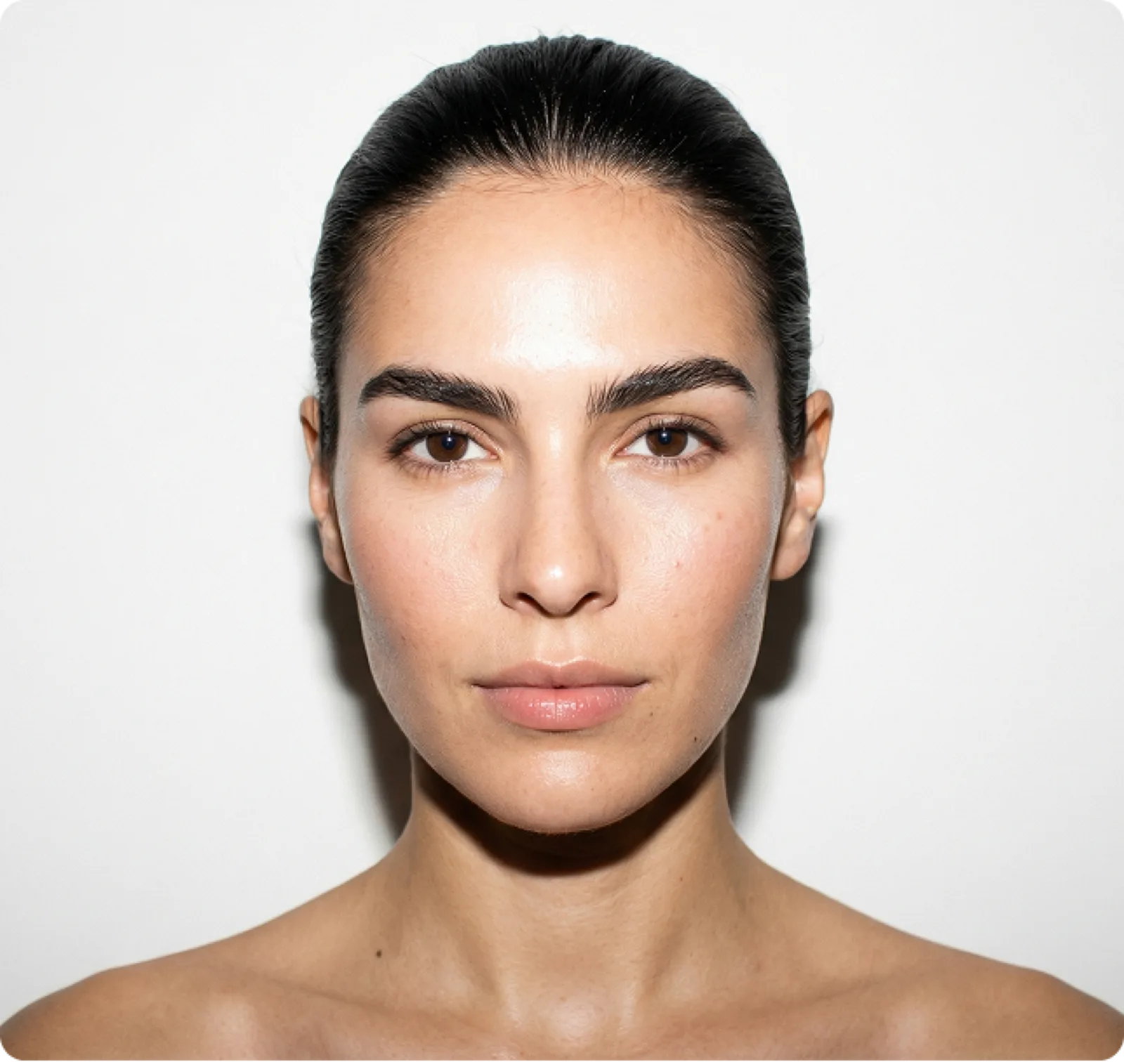 Mujer con piel luminosa sosteniendo un frasco amarillo de Moisturizer Base.